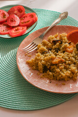 Dish of seafood risotto with fork on blue