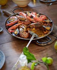 Plate with traditional tasty paella on table