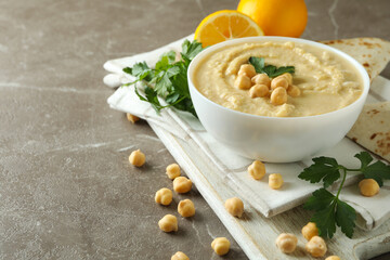 Concept of tasty eat with bowl of hummus on gray background
