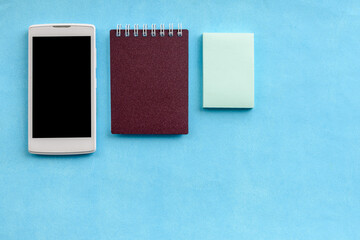 Top view of the mock up with office supplies and a smartphone