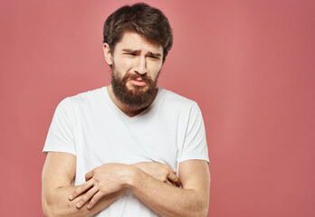 Sad man crossed his arms over his chest on a pink background