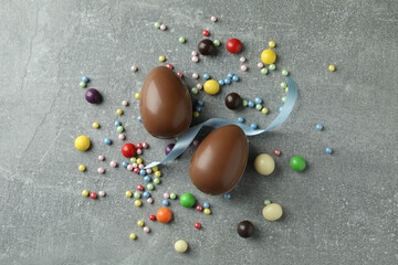 Easter chocolate eggs and candies on gray background