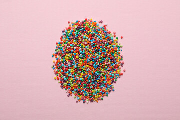 Egg made of sprinkles on pink background