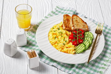 scrambled eggs with veggies and bread on a plate