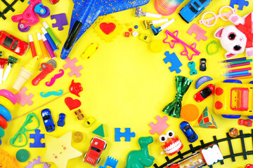 Many kids toys frame on yellow background. 
Childhood concept.  top view, flat lay. copy space 