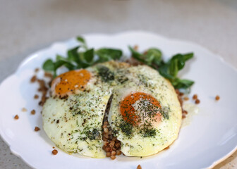 Fried egg with buckwheat and arugula on white plate