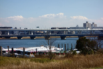 高速道路を見渡す、大型河川の岸辺に係留されたボート