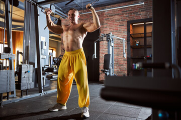 Fototapeta premium Joyful male body-builder working out at gym
