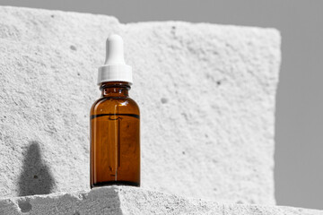 Glass jar of skincare serum on concrete block