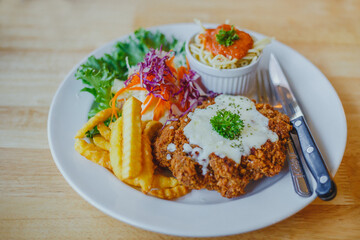 Fried pork chop, French fries and vegetables