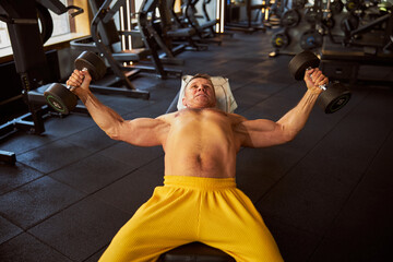 Naklejka premium Hefty sportsman having a proper dumbbell workout