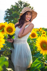 Summer look. Beautiful girl in sunflower fields.