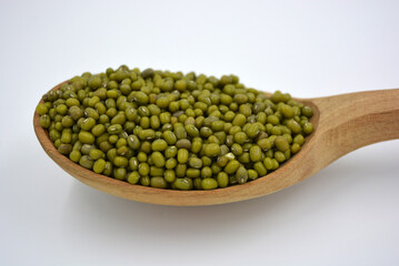 Handful of green Masha is messed in a spoon. Ukrainian abrupt spoons made of natural wood. Useful food, cereals, grain for human health. 