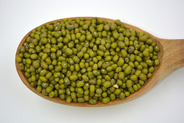 Handful of green Masha is messed in a spoon. Ukrainian abrupt spoons made of natural wood. Useful food, cereals, grain for human health. 