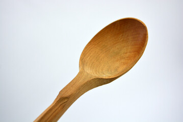 Products made of natural handmade tree. Wooden big spoon with carvings. Beautiful and unusual things on a white background. 