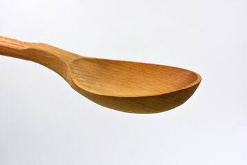Products made of natural handmade tree. Wooden big spoon with carvings. Beautiful and unusual things on a white background. 