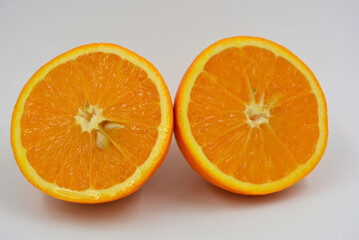 Useful and delicious fruits for human health. Orange oranges cut into two halves. Juicy fresh fades of orange with bones. 