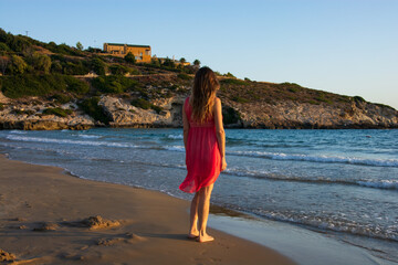 the girl in the red dress in front of the sea