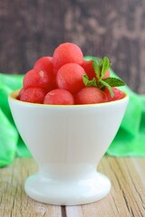 Watermelon balls in a bowl, garnish with mint leaf