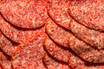 Slices of ham sausage as a natural background . Tasty salami slices ias a natural background . Smoked Sausage slices, as a natural background