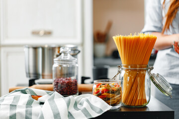 Unrecognizable woman cooking something near the stove in kitchen close up