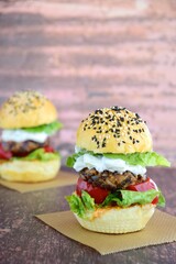 Vegetarian burger. Sesame bread bun with lentil patty, tomato, lettuce and yogurt