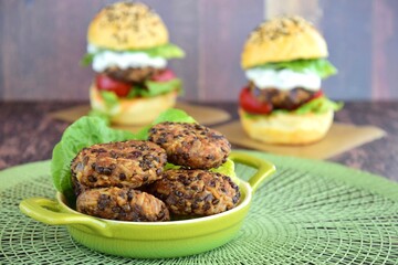 Beluga lentil rice patties with vegetarian burger on the background