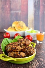 Beluga lentil rice patties with vegetarian burger and tomatoes on the background
