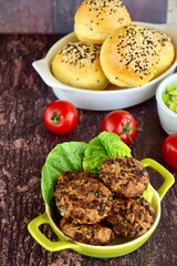 Beluga lentil rice patties with vegetarian burger and tomatoes on the background
