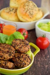 Beluga lentil rice patties with vegetarian burger on the background. Selective focus, blurred background
