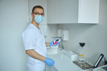 Pulmonologist with a handheld digital spirometer standing at his office