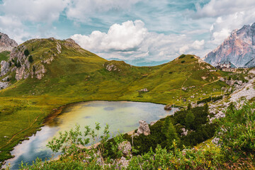 Valparola Pass with hut and with Lake Valparola in the foreground, Italy.