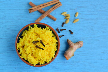 Turmeric rice with cinnamon, cardamom and clove. Blue background
