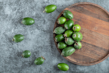 A wooden cutting board with fresh feijoa