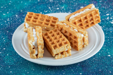 Delicious fresh waffles on a colorful background