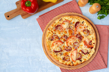 Delicious pizza with sausages on gray background