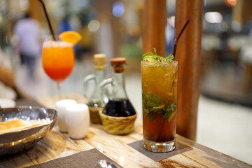A glass of Mojito cocktail - Made with lime, mint, cane sugar and soda on blurred background and with copy space.