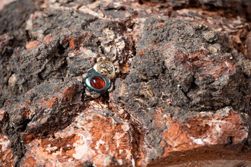 Decoration in the form of a cartoon bear made of bronze and amber against the background of a wooden texture close-up. High quality photo