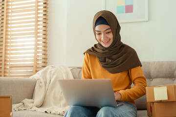 
Muslim young women wear hijab using typing and checking order customer address on laptop 