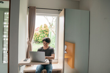 handsome asian modern man designer working home using laptop at home