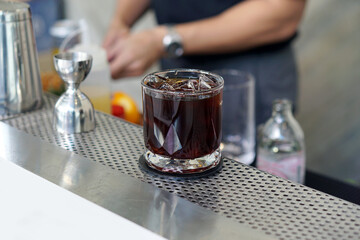 Iced americano - A glass of black coffee on table and copy space, The style of coffee prepared by brewing espresso with water and orange peel, Refreshing summer drink concept.