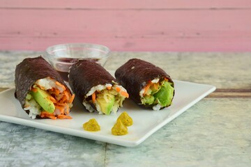 Homemade Sushi with carrot and avocado served with soy sauce and wasabi

