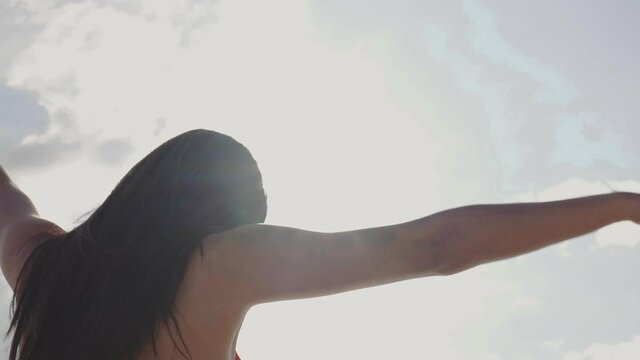 Back view of Asian woman in bikini walking by beach. travel vacation and lifestyle in sunset on summer weather