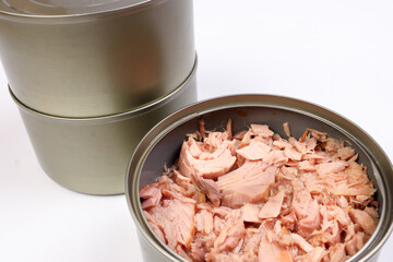 Tuna fish meat flaky chunk in tin can on white background