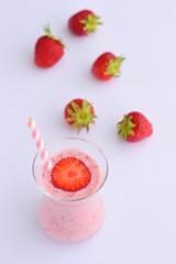 Strawberry smoothie in glass on white background