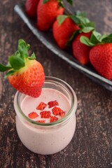 Fresh organic strawberry smoothie in a jar on wooden background