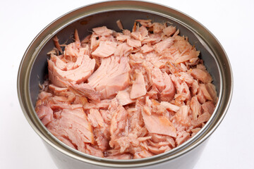 Tuna fish meat flaky chunk in tin can on white background