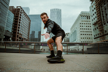 Caucasian male athlete stretching before run in city 
