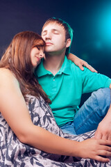 Fototapeta premium Portrait of Pregnant Caucasian Woman with Husband Posing Together Embraced Against Black.