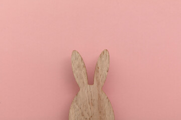 Minimal easter holiday background. Wooden easter bunny on pink